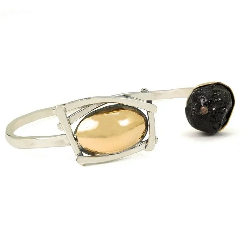 This sleek mixed-metal cuff anchors a capped black tourmaline, accented with a subtle drift-inspired motif. Classic ME craftsmanship shines in every curve and detail, balancing clean lines with organic movement that you&rsquo;ll want to wear every da