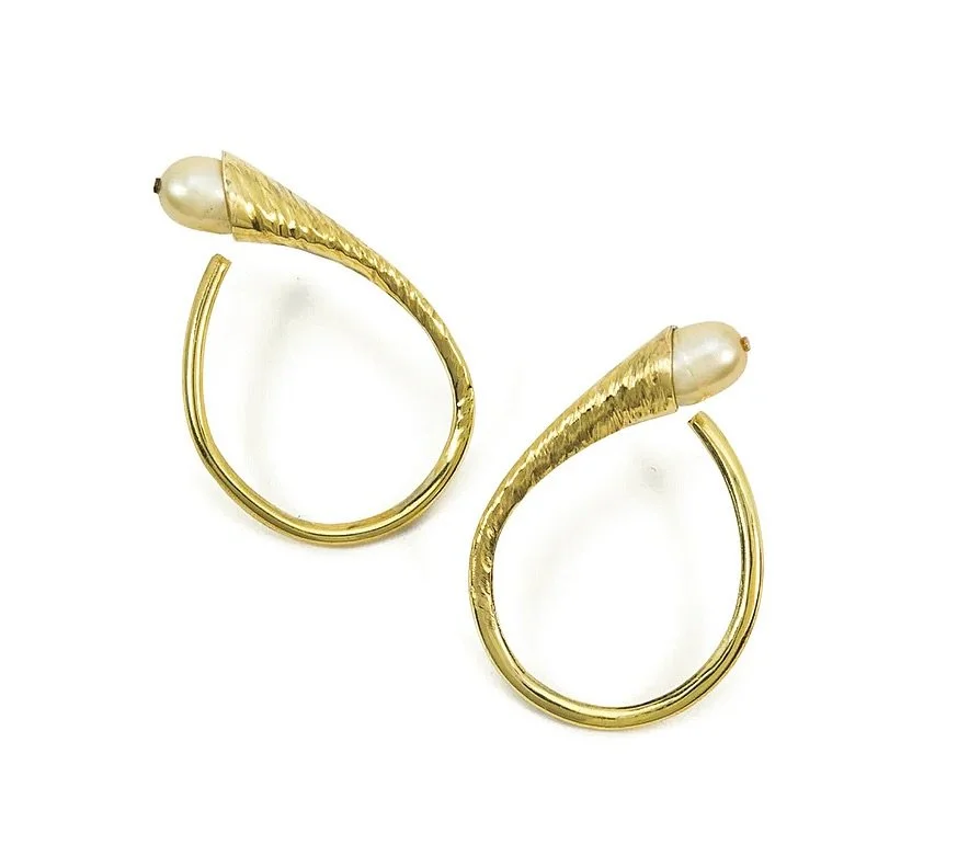 The Calla Hoops is an instant classic.

Designed to subtly tuck just behind the ear, with the surprise of a pearl.

Sculptural. Fluid. Effortless.
