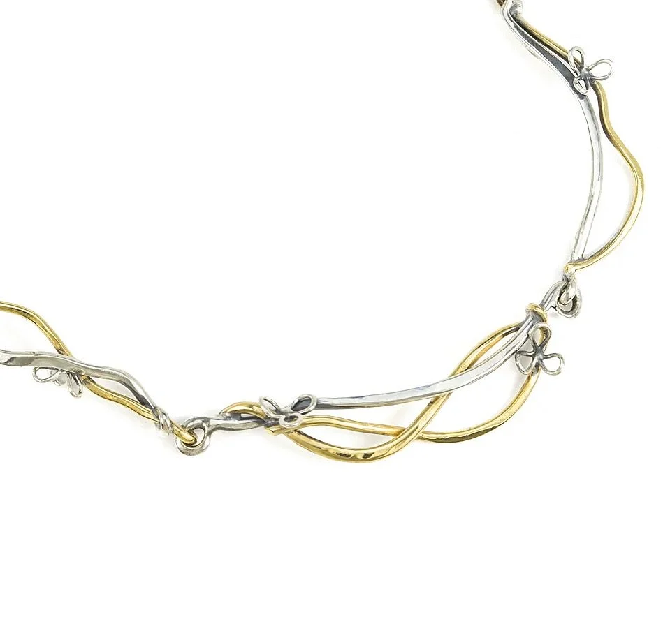 Perfect is overrated.

Twisted, irregularly hammered wire forms a mixed metal collar with an organic edge. Texture over polish&mdash;where imperfection is the point. 😎