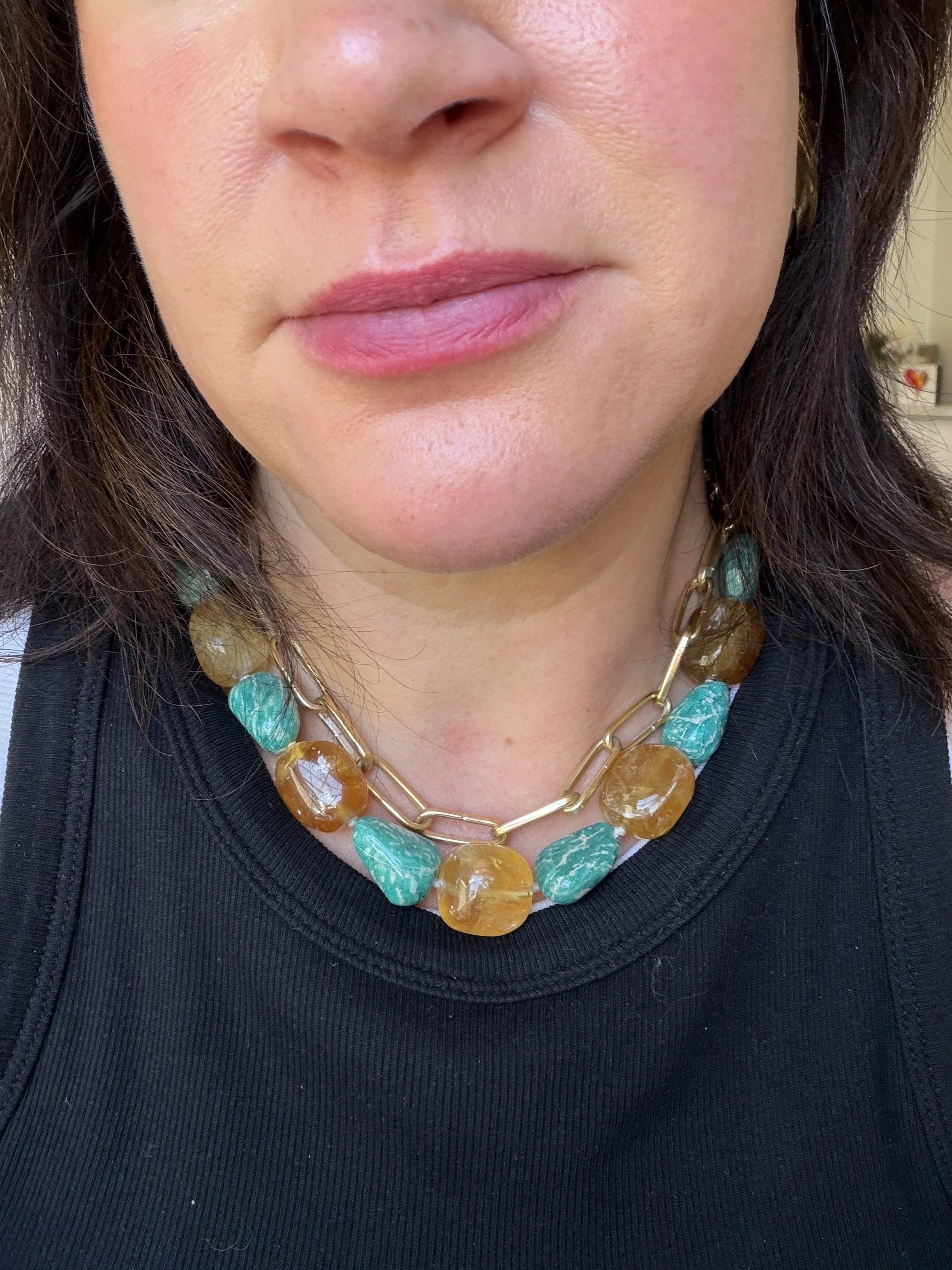 honey calcite and amazonite stone bead necklace layered with a gold chain on a woman's neck