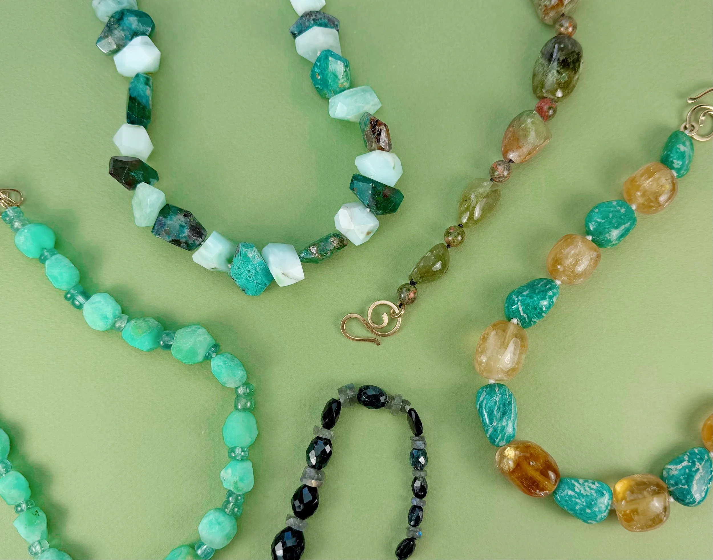 semiprecious stone bead necklaces on green background