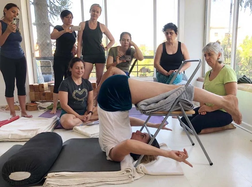 Senior Iyengar Yoga Teacher Lara Warren demonstration supported plow pose.