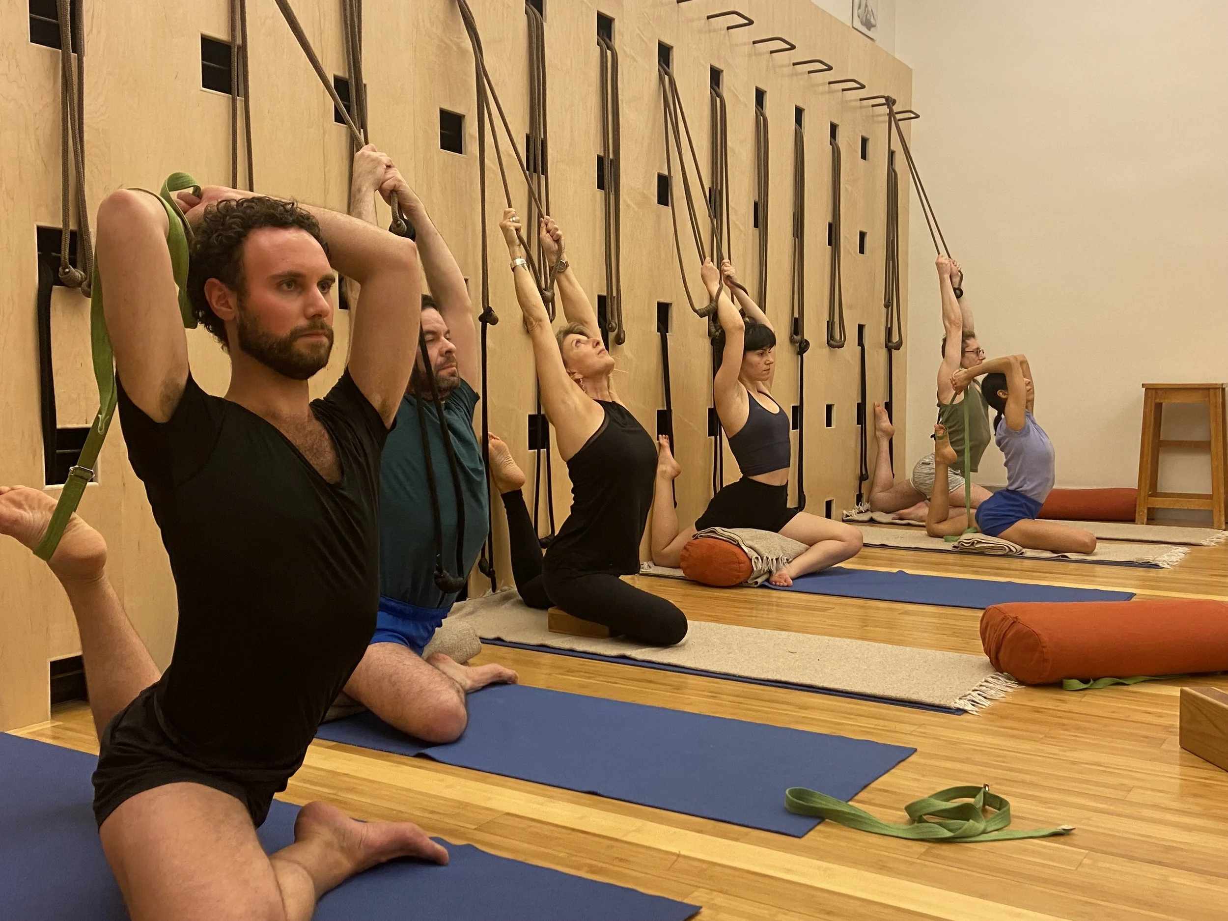 Yoga students practicing pidgeon pose at the Iyengar Yoga Institute of New York in Lara Warren's Level 3 class.