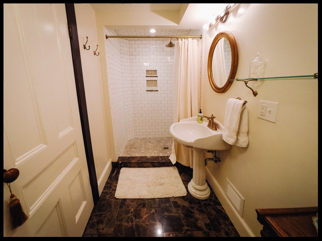 Empire room with tile shower and pedestal sink
