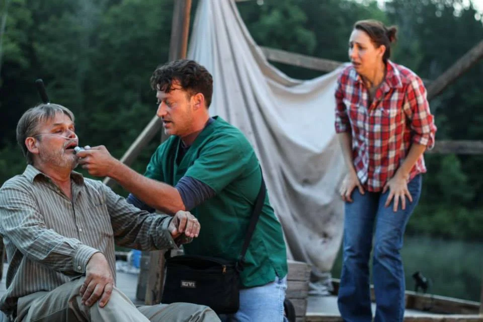 Howard (Mark Kincaid) gets aid from Donny (Brian Brendle) while Maggie (Veronica Duerr) stands frantically by.