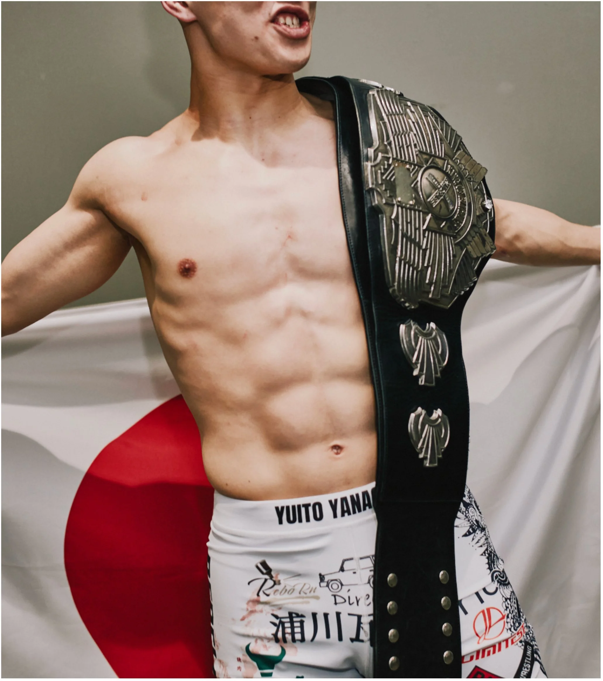 MMA fighter holding a championship belt in front of a Japanese flag — Shura No Hana MMA documentary, Tokyo | Victor Marvillet photographer