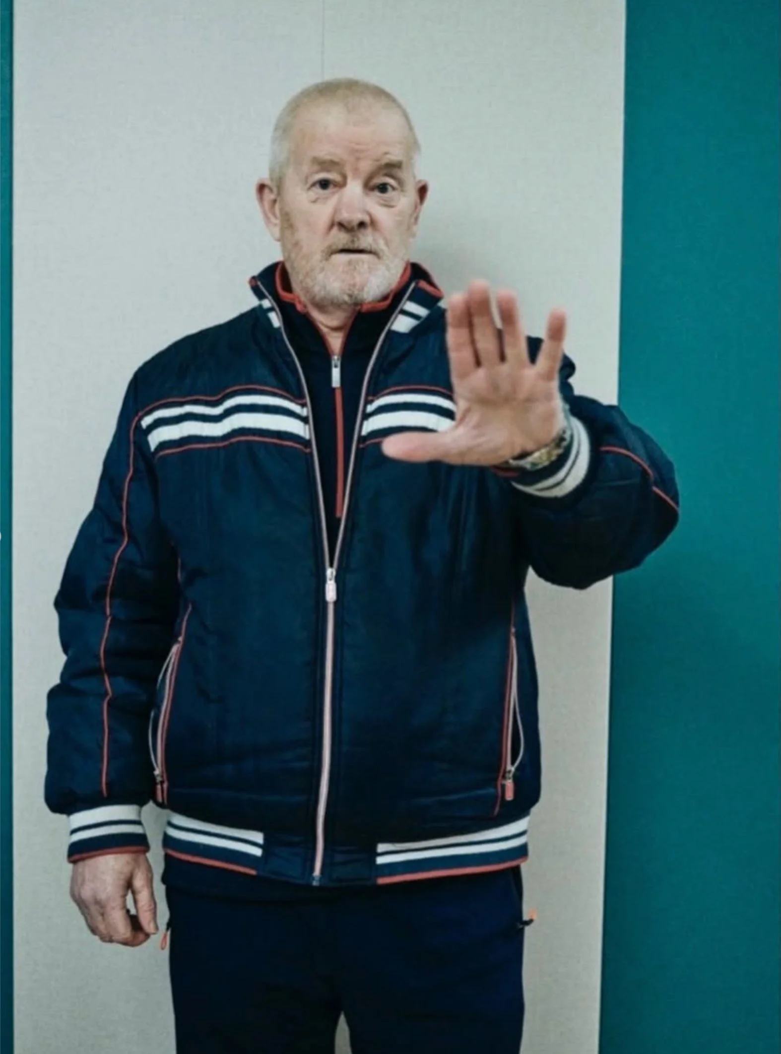 Older man in a track jacket raising his hand to the camera — Shanghai fashion and portrait photography | Victor Marvillet photographer