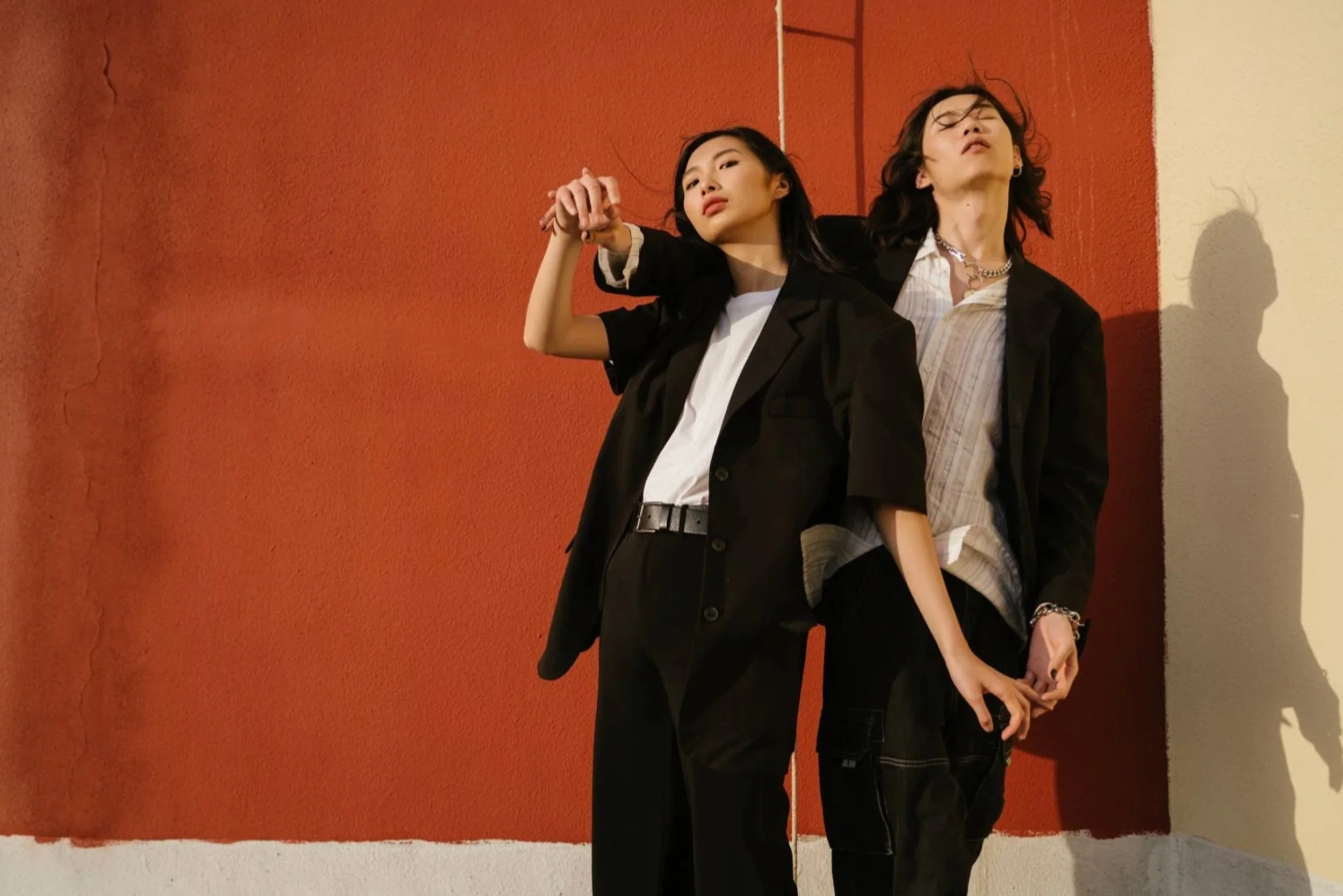 Two models in black suits leaning on an orange wall — Shanghai fashion and portrait photography | Victor Marvillet photographer