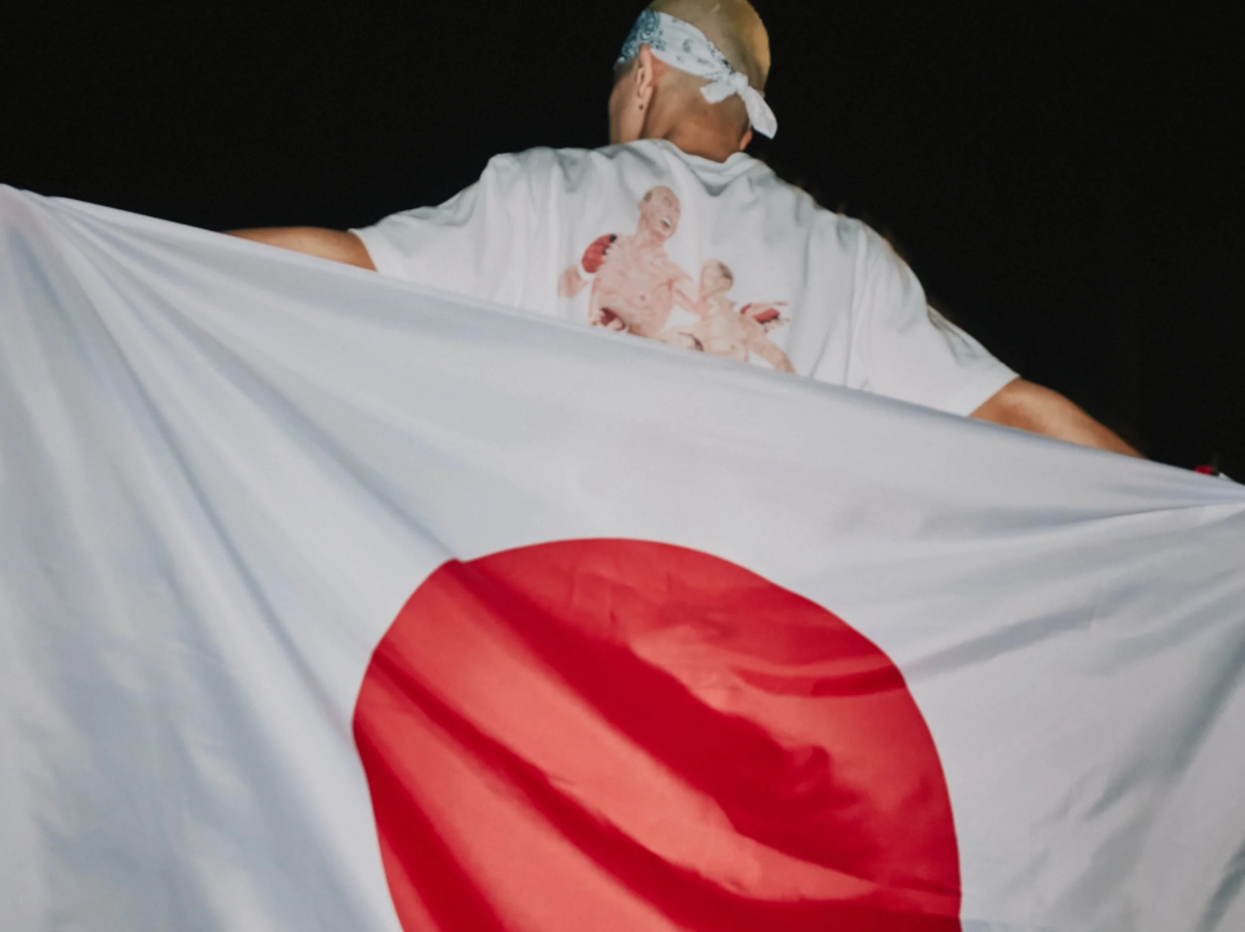 Fighter draped in a Japanese flag with a cold towel on his face — Shura No Hana MMA documentary, Tokyo | Victor Marvillet photographer