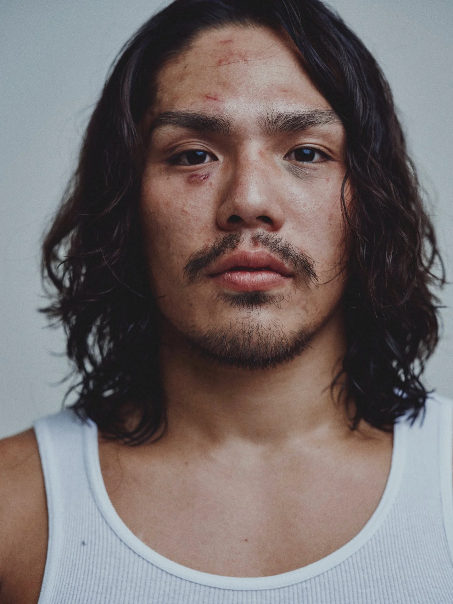 Portrait of a long-haired fighter in a white tank top — Shura No Hana MMA documentary, Tokyo | Victor Marvillet photographer