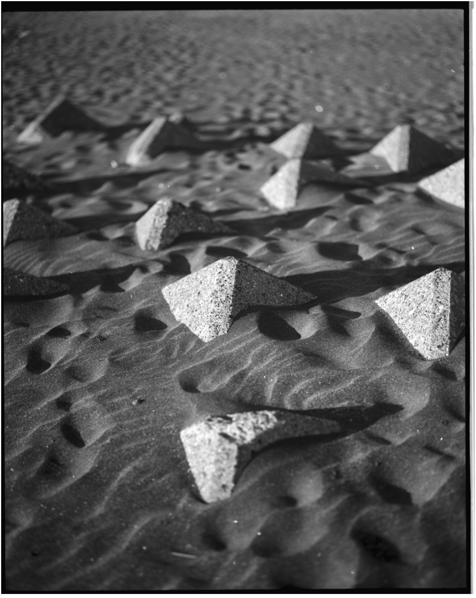 Triangular concrete objects scattered on sandy beach, Archipelago photo project, Japan — Victor Marvillet photographer