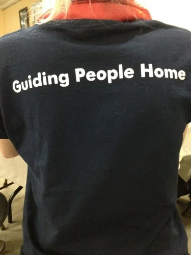 A staff member wears a T-shirt with the Miriam's Kitchen motto on the back.