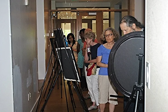 Attendees view an art exhibit at Gandhi Brigade Youth Media Festival