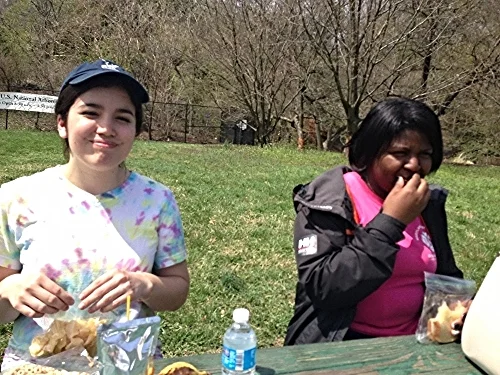 Claire and A'Lexus picnic on their lunch break at the National Arboretum during a City Kids canoe trip