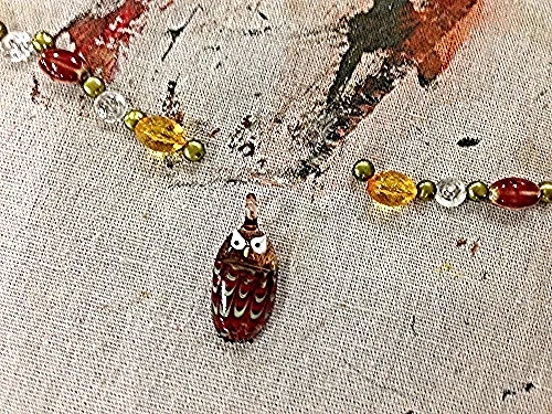 Shandell creates a pattern of beads for his wise owl necklace. 
