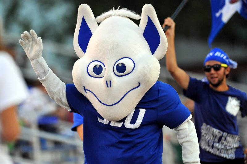 The last iteration of the Billiken, here given three-dimensional form as a courtside costume. Photography credit unavailable (SLU Athletics, 2012). I wrote in 2010: Look at that meandering mouth, the blank yet slightly cross-eyed gaze. Doesn't he look like he's trying to pass a sobriety test? Does he have any hope of intimidating an opponent? Of course not–he's trying to touch his nose! On the positive side, he's got enviable sneakers, and his italicized SLU seems slightly aggressive.