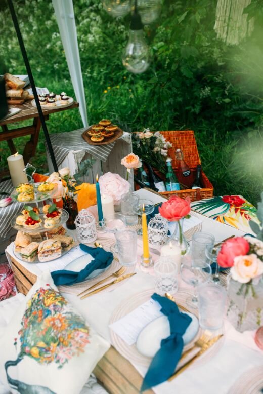  Classic British afternoon tea with a twist in a fun, boho, rustic &amp; romantic style. Apple Crate picnic table . Stylish Rustic Tablescape, nordic stoneware plates, gold cutlery, Parisian blue napkins, Long coloured candles, coral and white peonie
