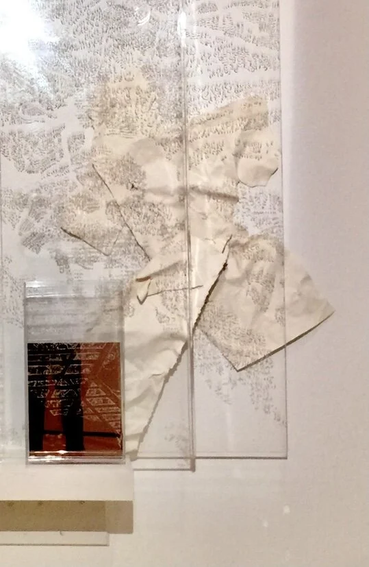 the image carved into the plexiglass layers is of young boys playing at being men with long spears, in the lush forests.  the crushed and folded paper is as if discarded waste