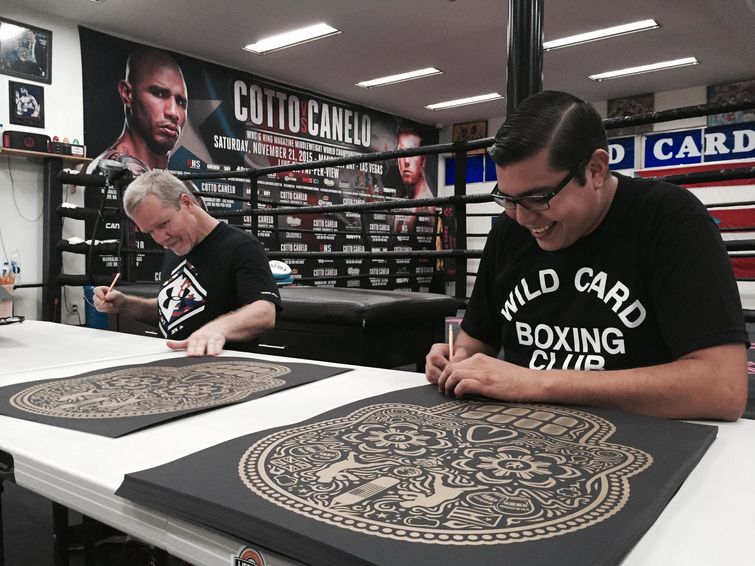 Freddie Roach and Ernesto Yerena Montejano signing prints together at Wild Card Boxing Club in Hollywood, CA.