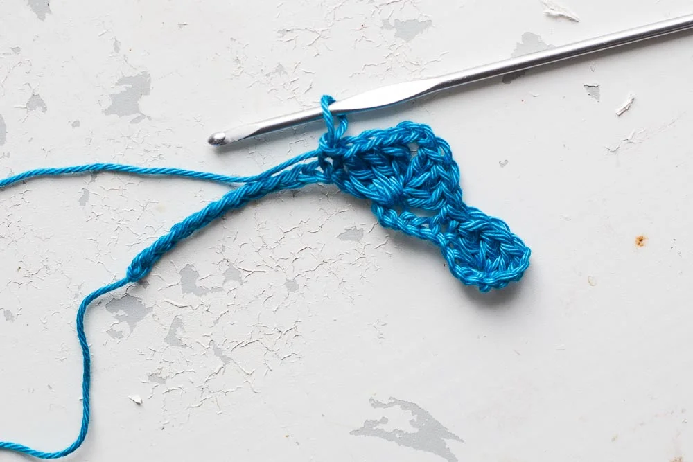 Step 6: Miss 5 chains from the cluster you just made (or 1 stitch from the first set of trebles you made). Double crochet 1. 