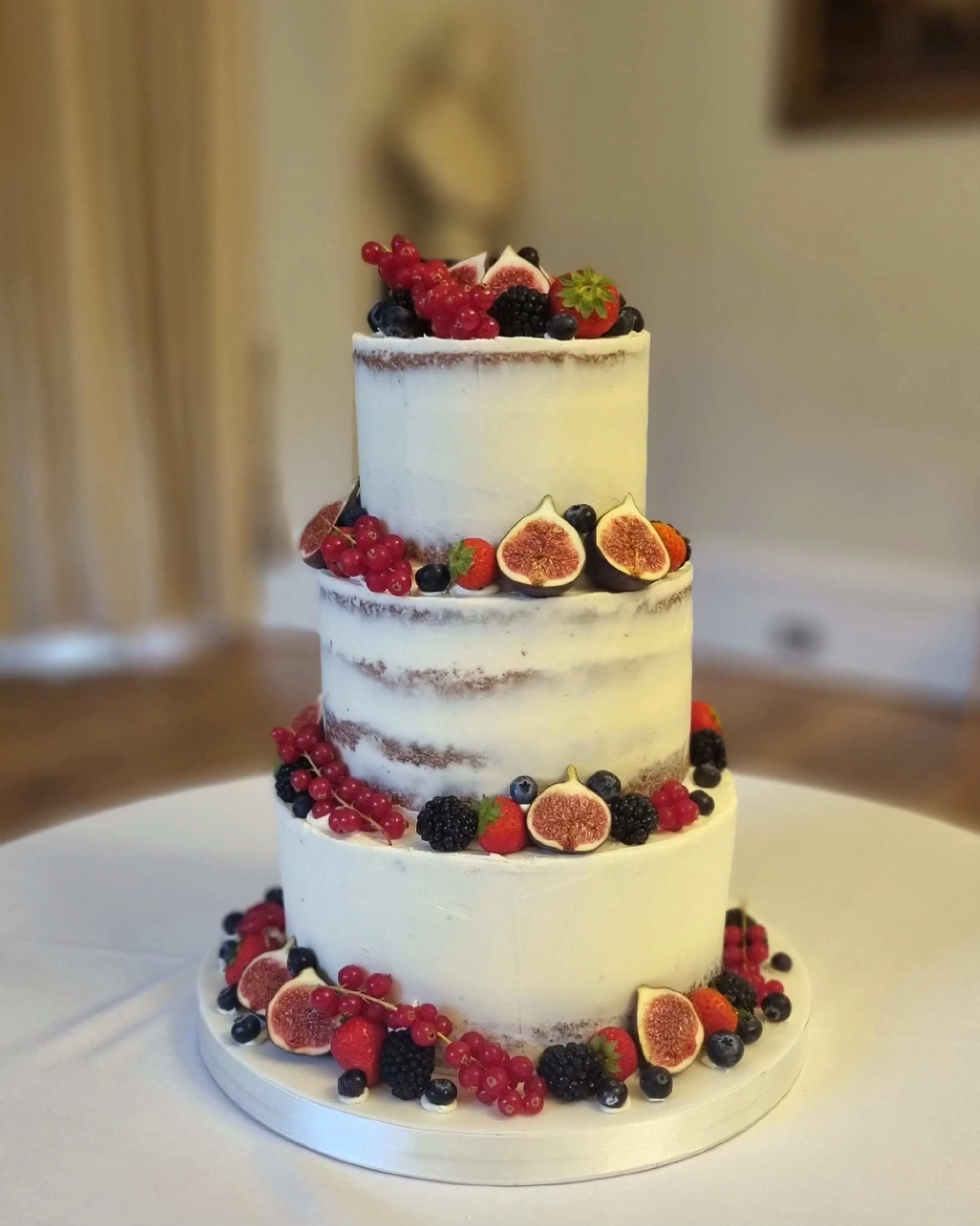 semi naked wedding cake with fresh fruit berries figs