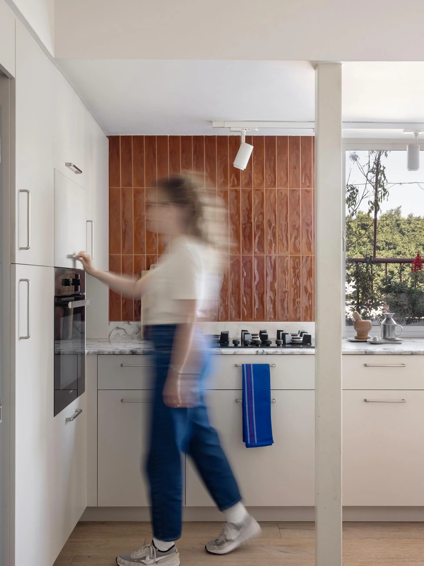 ממשיכה את הדירה המנחמת.  בפייסבוק כשתנוח עלי הרוח, אכתוב פוסט ארוך המפרט את כל התהליך המתוק. מטבח עם משטח אבן טבעית, שנראה כמו אחד מצבעי המים של בעלת הבית. יחד עם אריח מטבח עמוק שמהדהד לנו קצת שנות ה70, נוצרה כאן חומריות יצירתית שמפיצה חום. שולחן האו