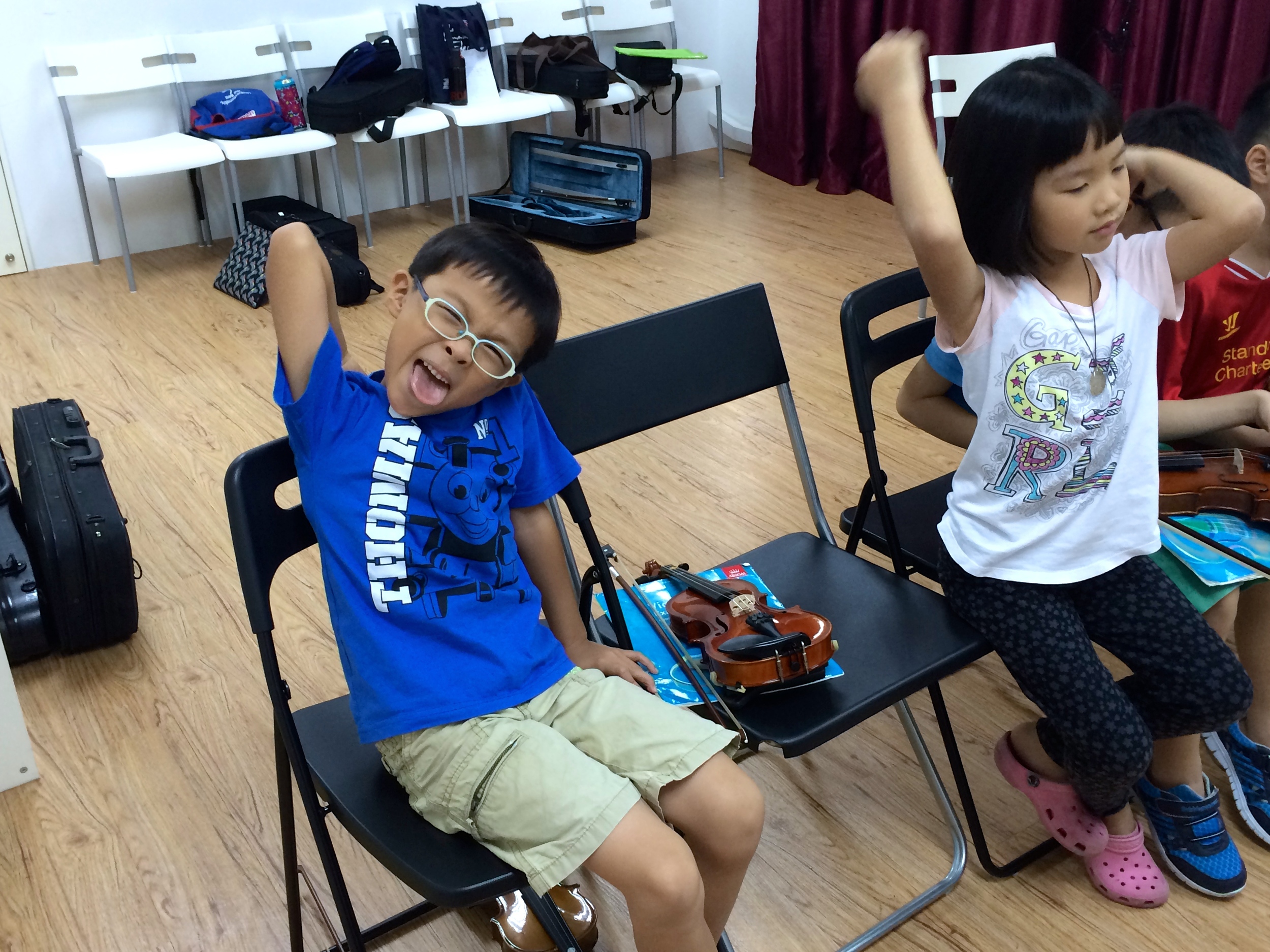 Our students, exhausted from 3 hours of intense violin playing and their messy bags in the background!