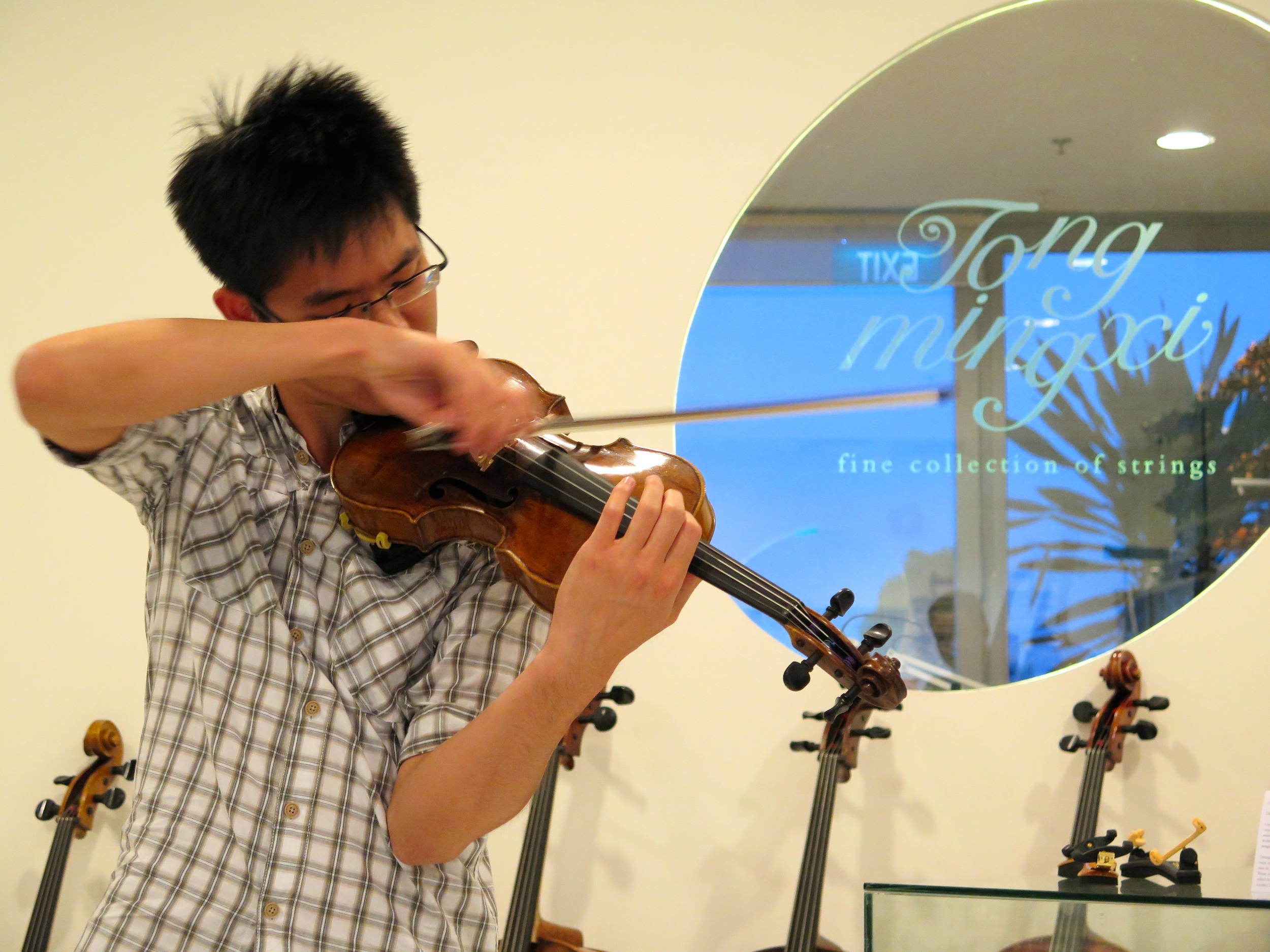 Violinist Alan Choo playing on one of the violins on display