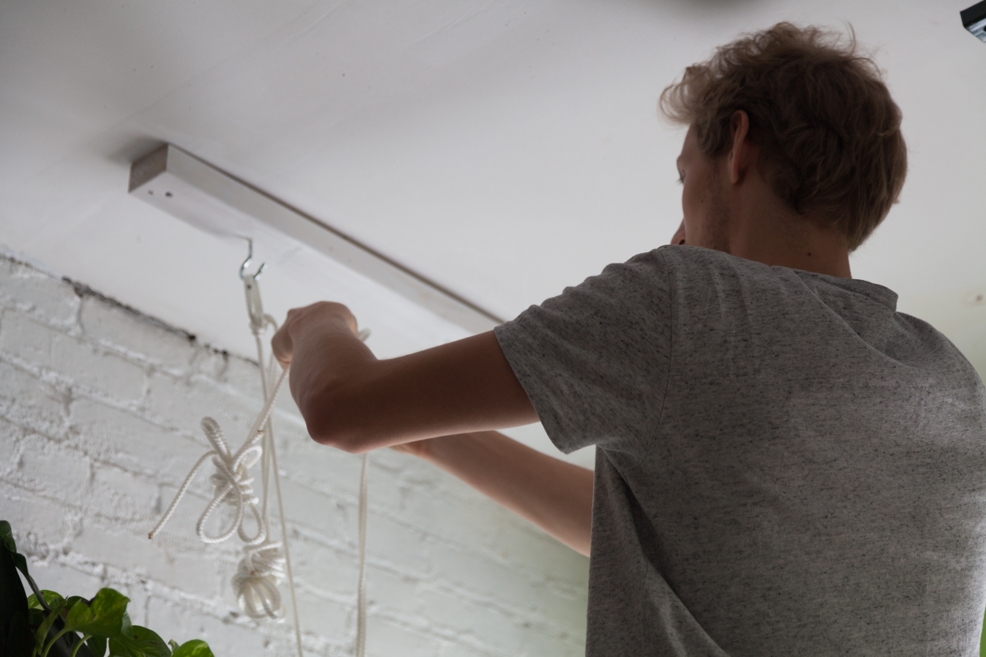 Once the wood in the ceiling was painted, Sander began to loop the rope. 