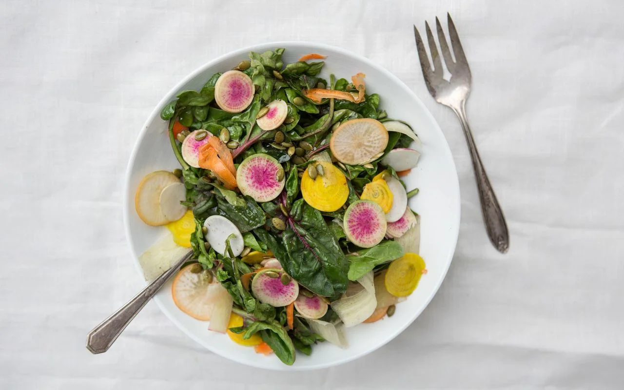 Spinach salad with shaved vegetables and pumpkin seeds