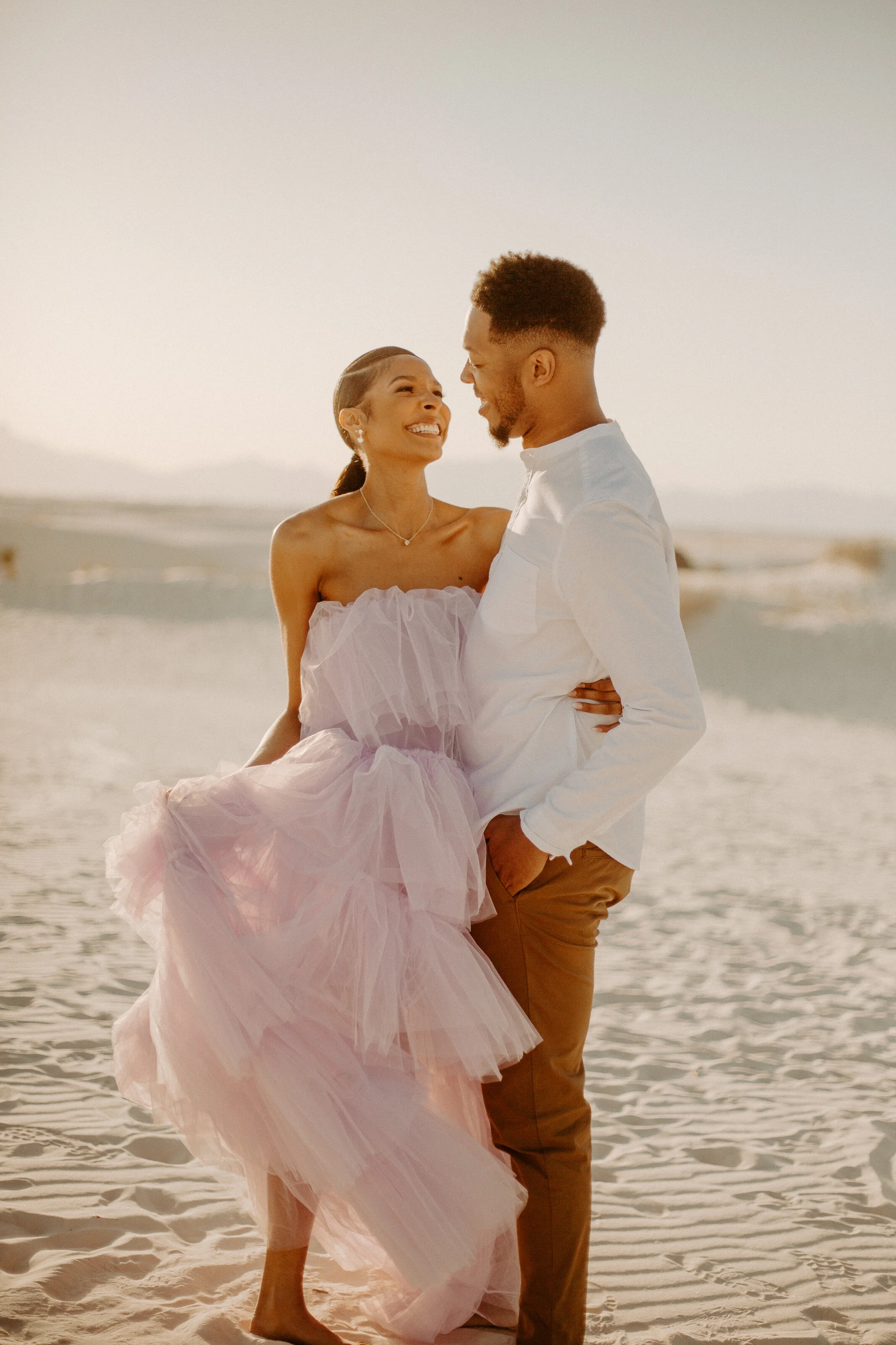 A couple sharing a joyful moment during their White Sands engagement session