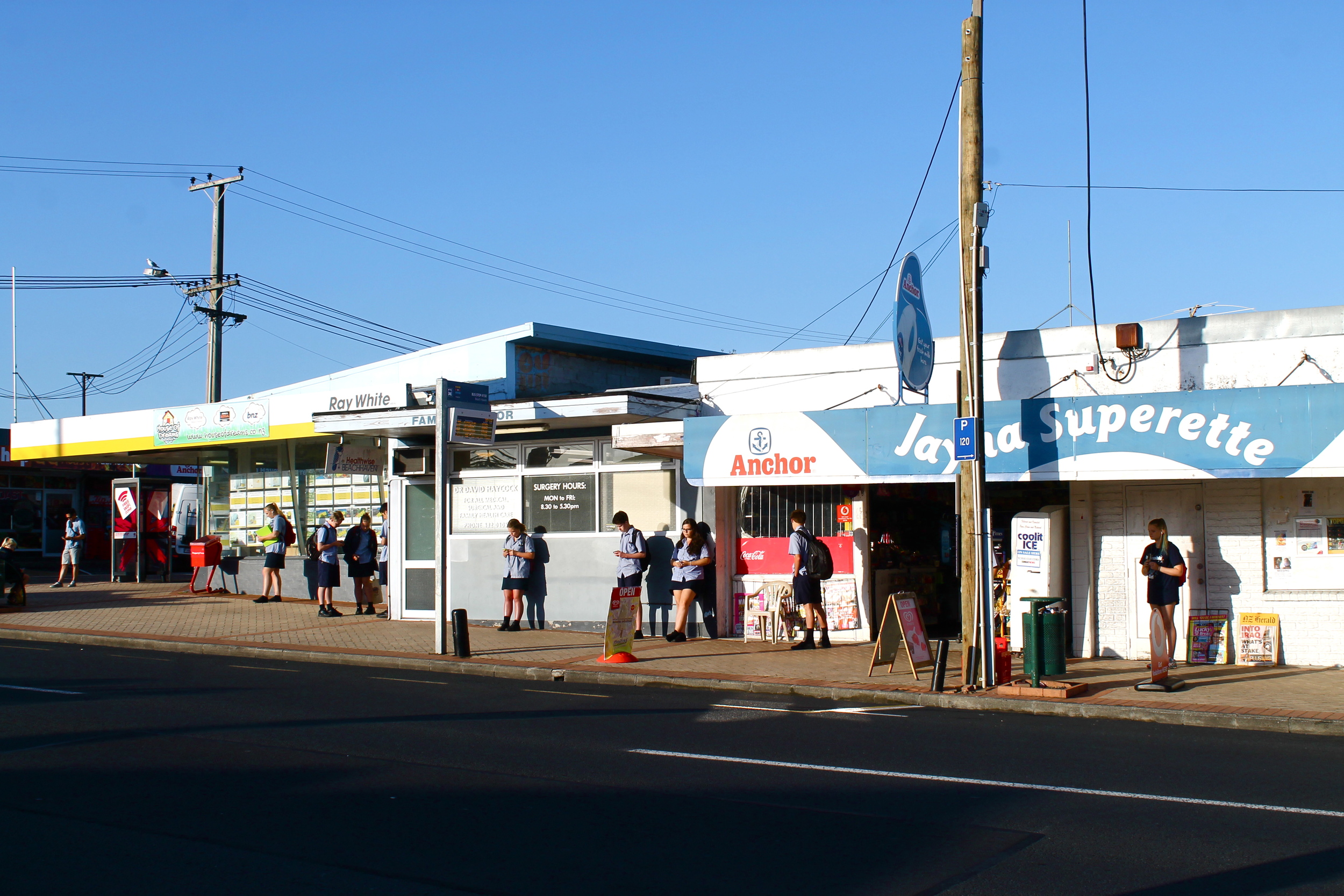 Uniformed school kids at the Beach Haven bus stop. 