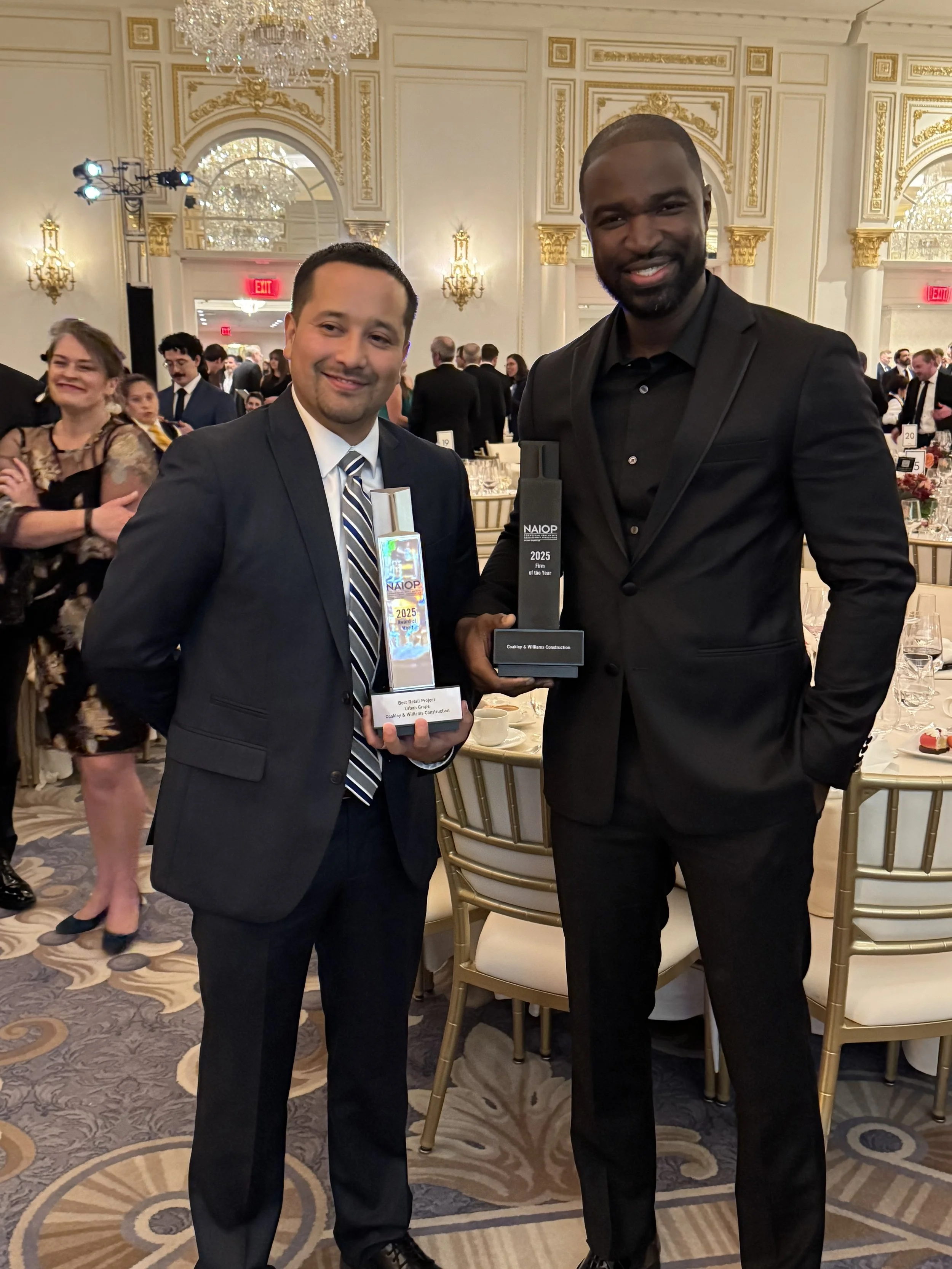 Jonathan Fuentes (Senior Project Manager) & Baboucarr Cham (Public Business Unit Leader) hold the NAIOP DC|MD trophies.