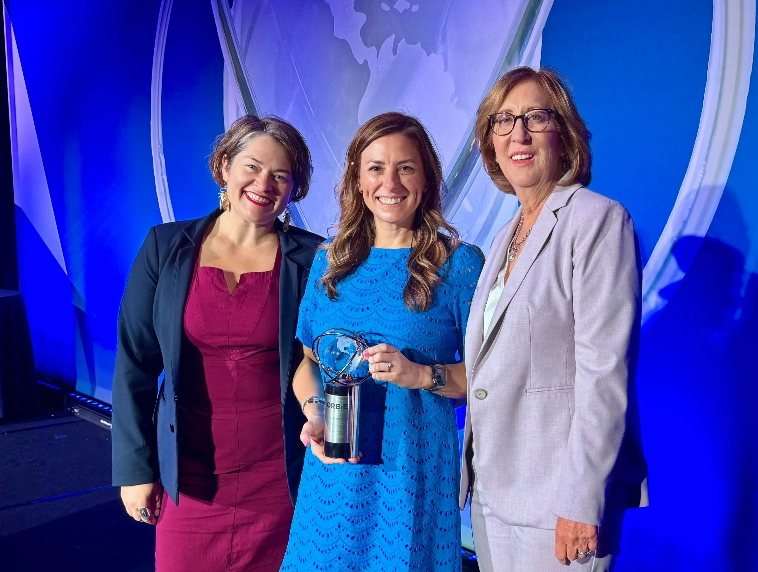 Mary Butcher, Lisa Schlossberg, and Lynn Stith Bennett celebrate Lisa's 2026 CapitalCMO Corporate ORBIE Award recognition.