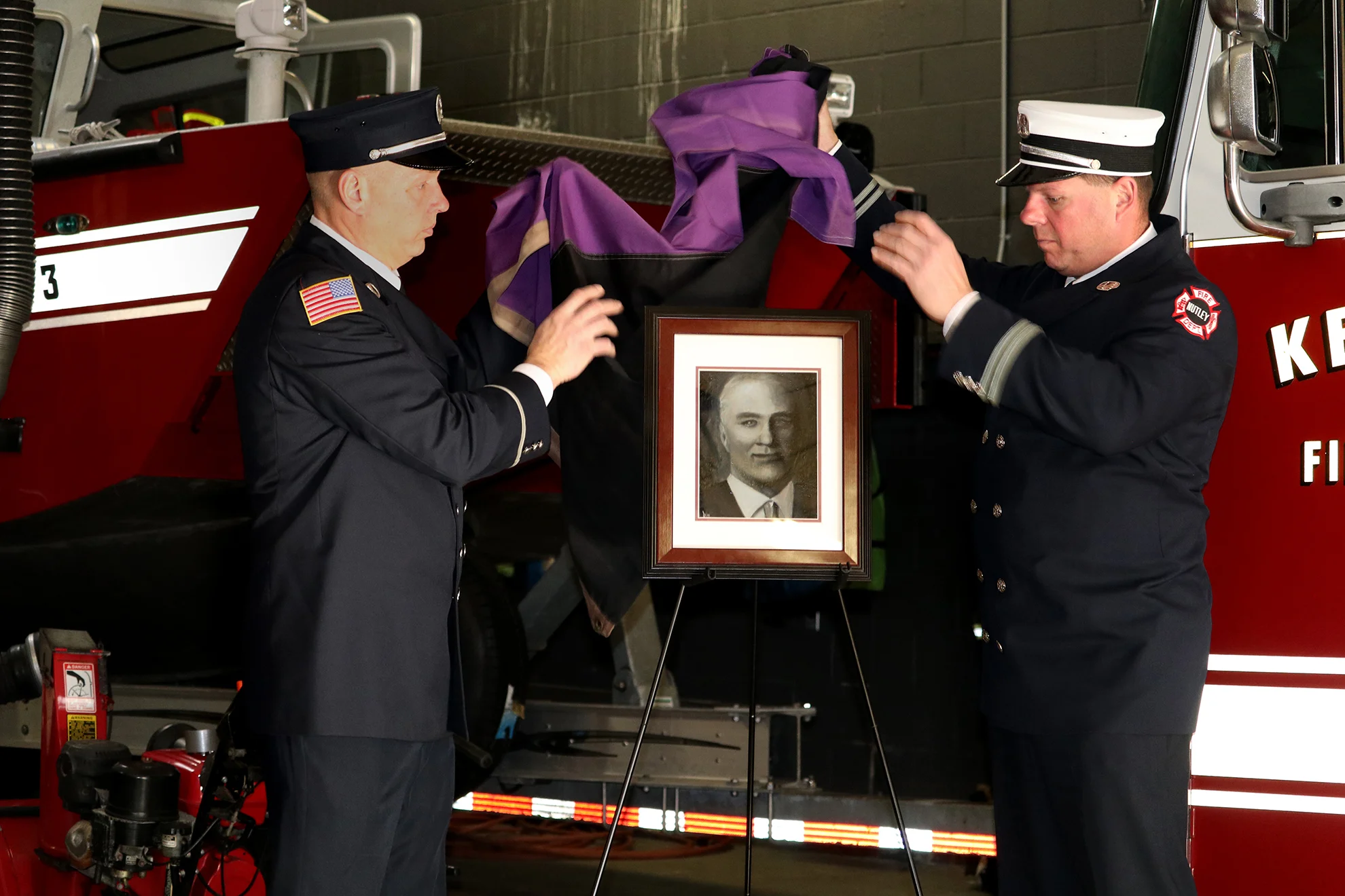 Descendants of Firefighter Robert Hamilton unveil Jen Bissu's oil portrait of him at the ceremony.