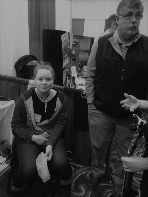 granddaughter of sheila dassatt and website editor sits by president hilton turner at a successful fishermens forum.