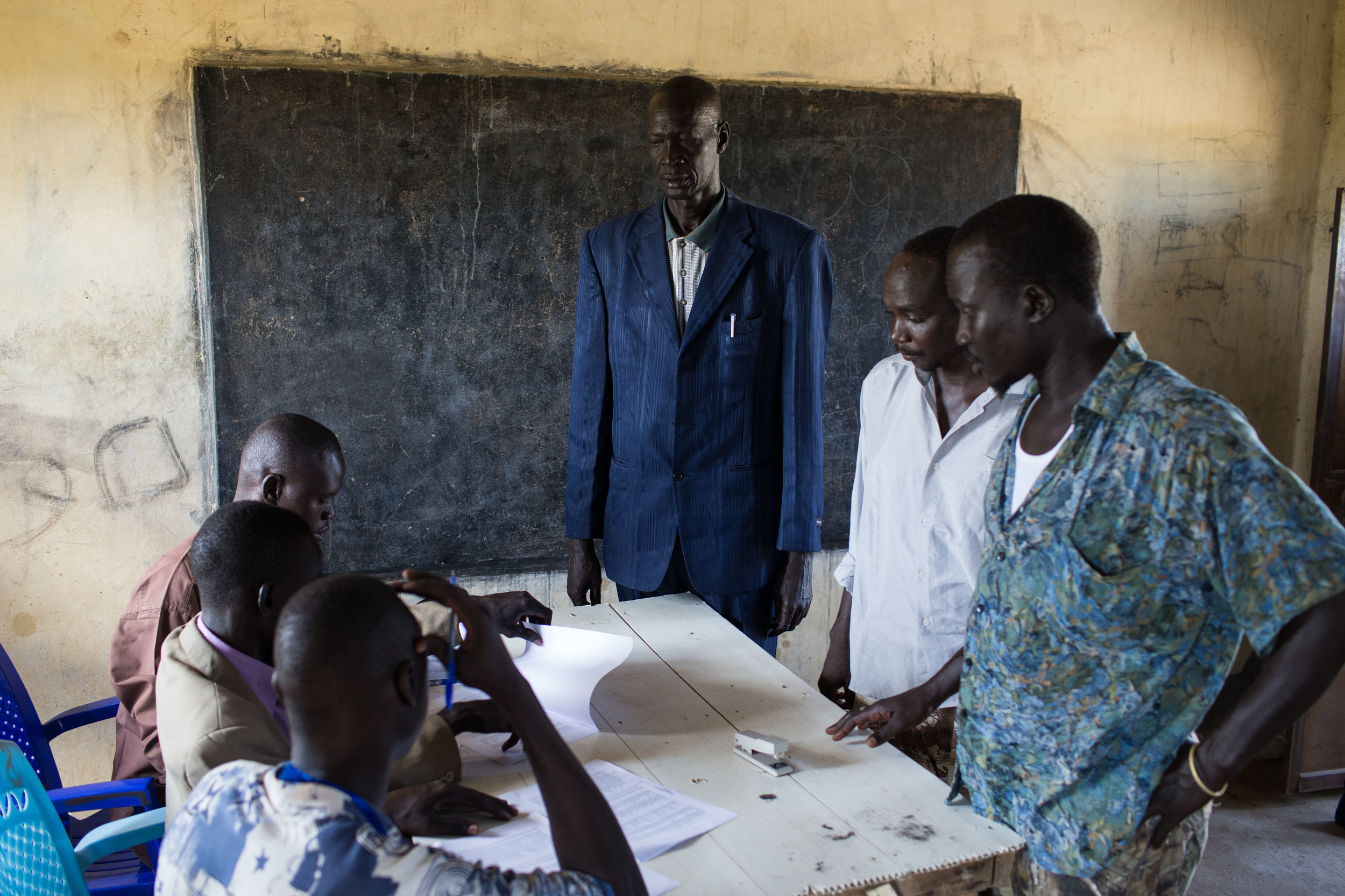  Men check their names on the registration list in an abondened school converted into a voting center in Abyei. 