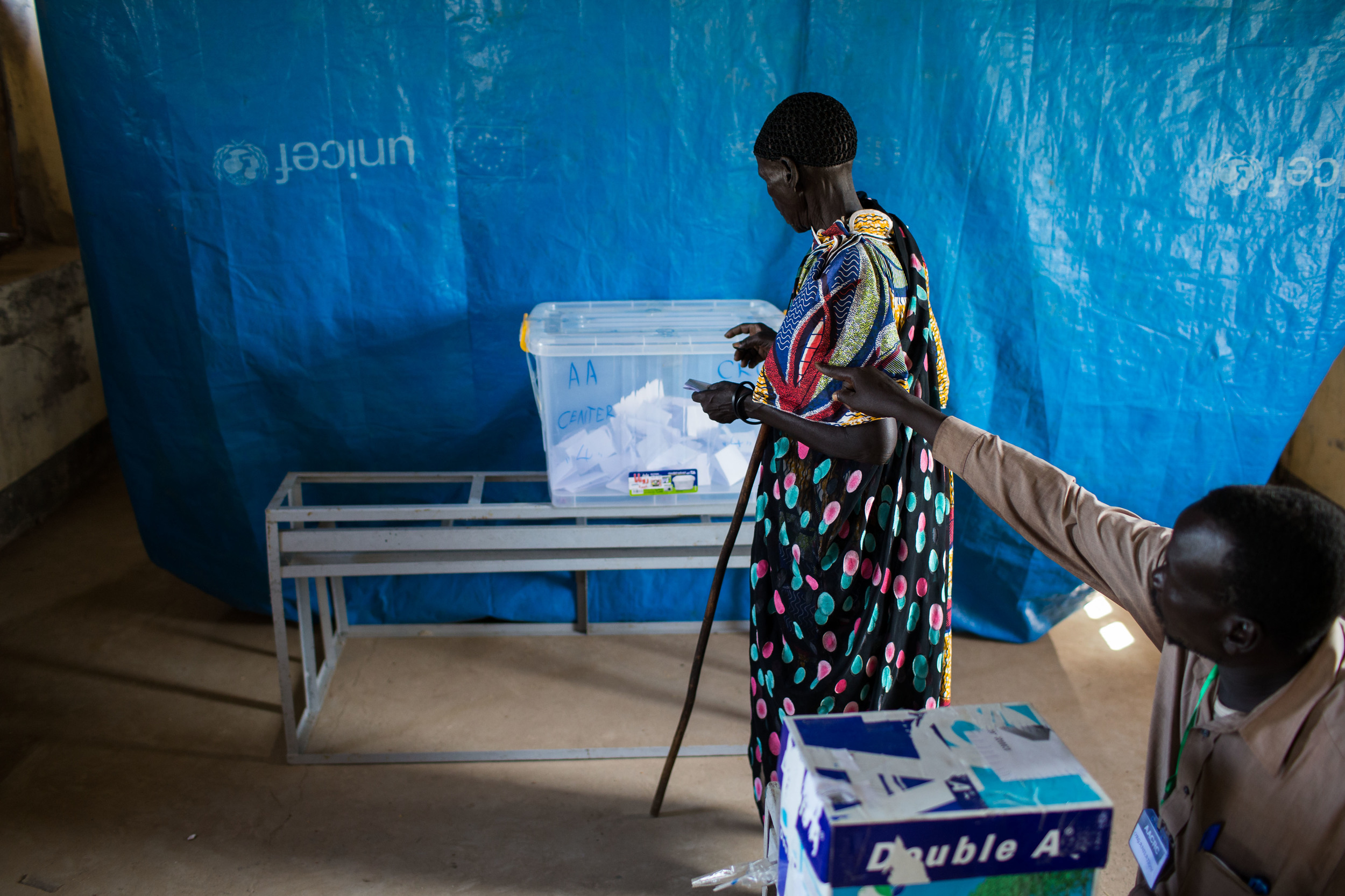  A volunteer with the AACRC directs a woman where to cast her vote at a voting centerin Abyei. 