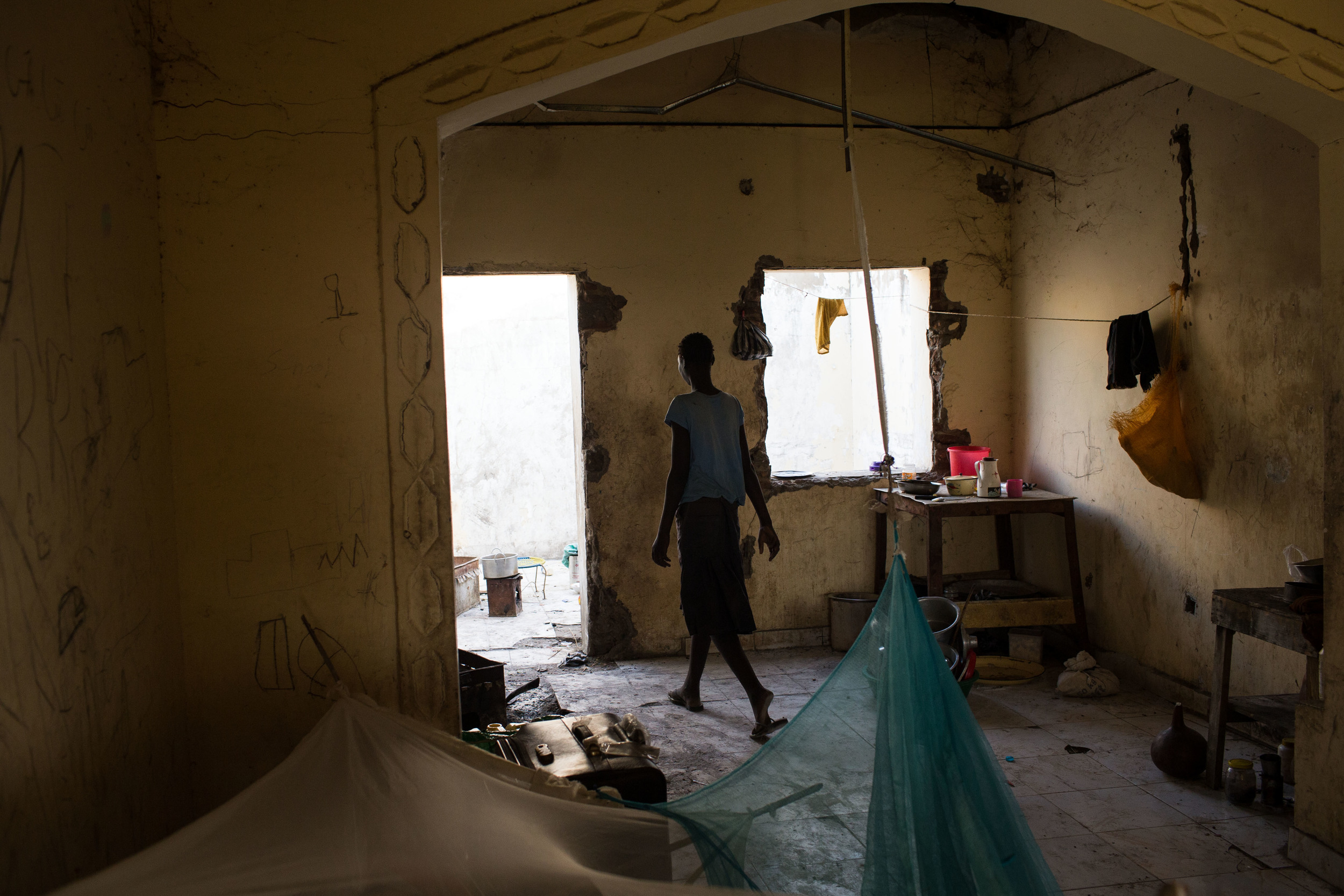  A young girl walks through the kitchen of an abandoned house she and her family are temporarily living in while in Abyei to vote. 