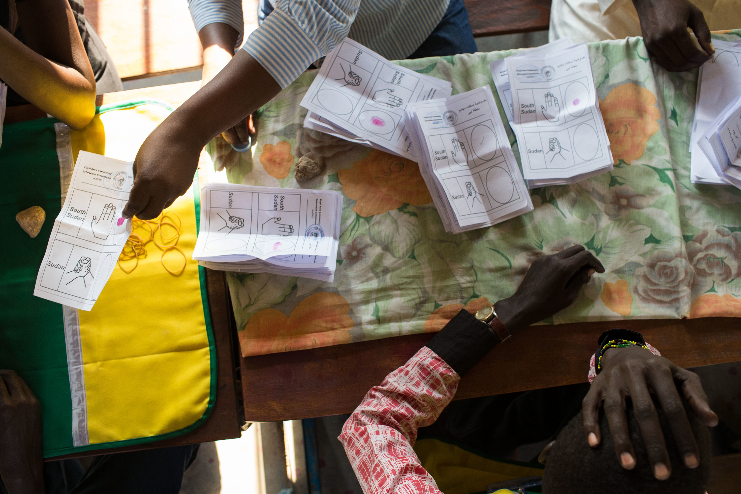  A volunteer with the AACRC holds his head while he and other volunteers count votes in Abyei. 