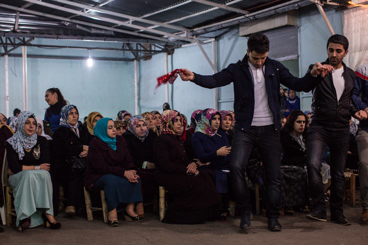 Kurdish women watch as young men dance by in a traditional Kurdish wedding ceremony in Diyarbakir.