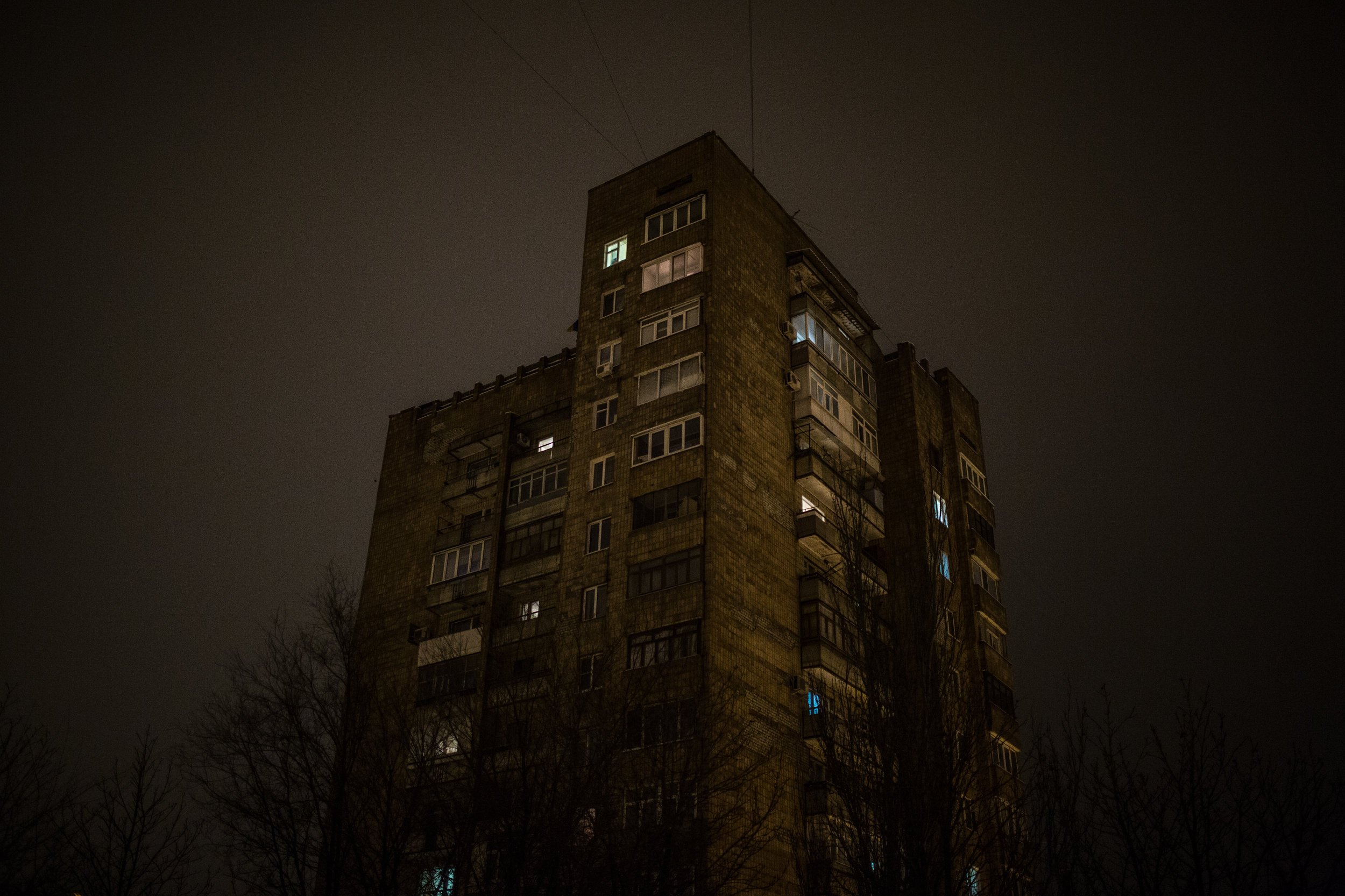The lights of different apartments are seen through the windows of a large housing block in Kramatorsk. Kramatorsk has absorbed more than 67,000 people displaced by the conflict that has split much of the Donbass region in eastern Ukraine.