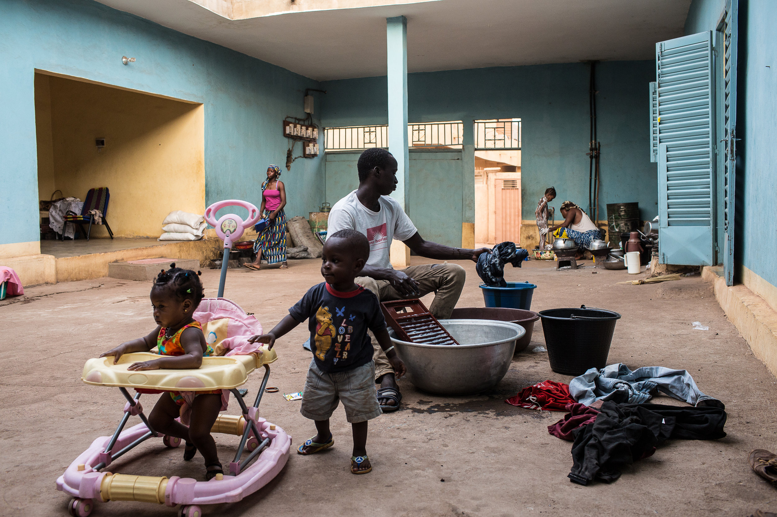 A young man named Mahamadou Doukara, 25, washes his clothes at the compound where he lives in Marseille. His family sent him from his village in Western Mali to live with his aunt in Marseille four months before in order to wait for his chance to attempt reaching Europe - a journey he has learned he will soon begin.