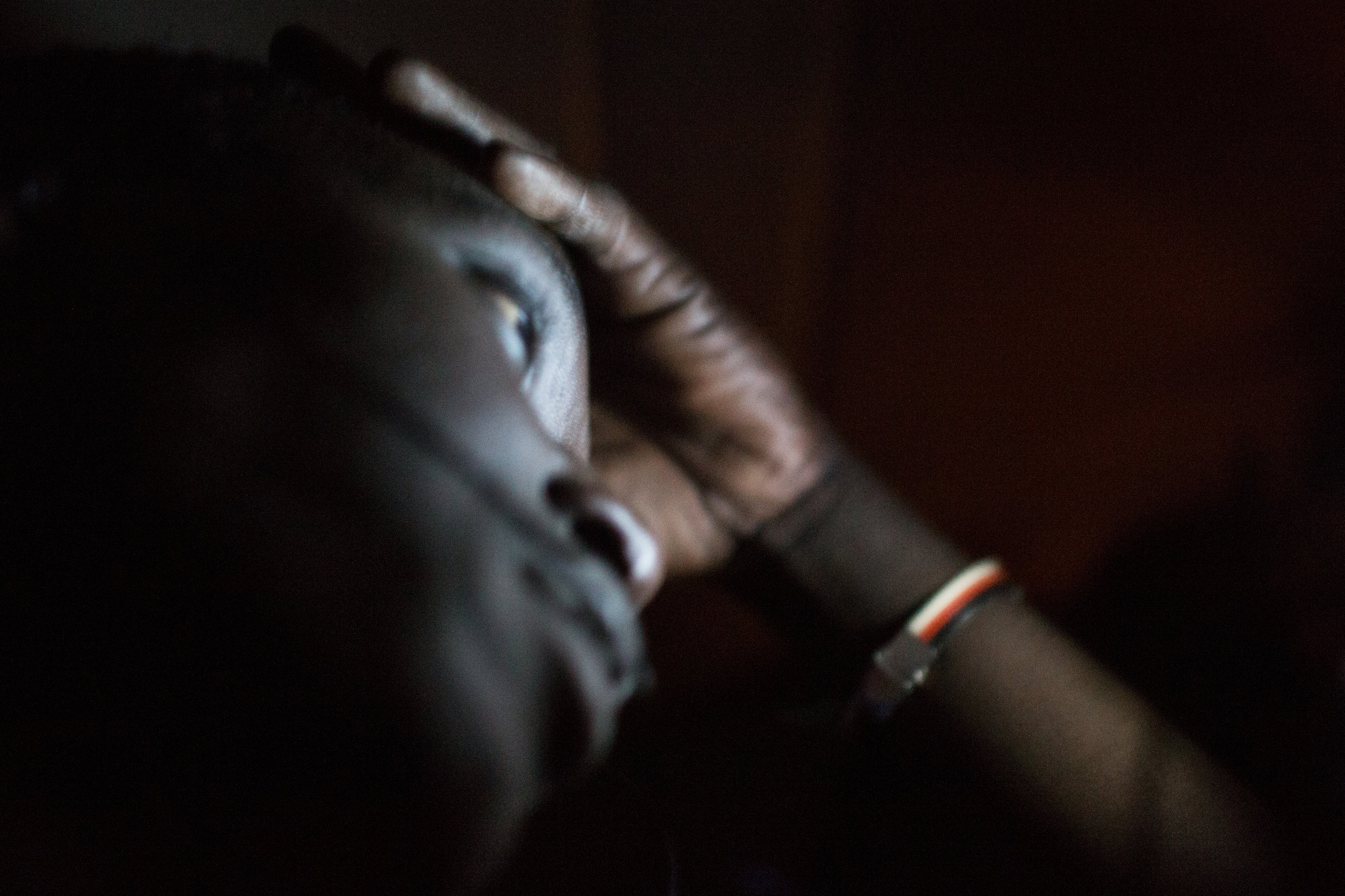 Exhausted and stressed, Mahamadou holds his head as the car drives late into the night towards Morocco. Without enough to pay the 500 Euro bribe Moroccan officials demand at border, Mahamadou will be turned back at the border early the next morning.
