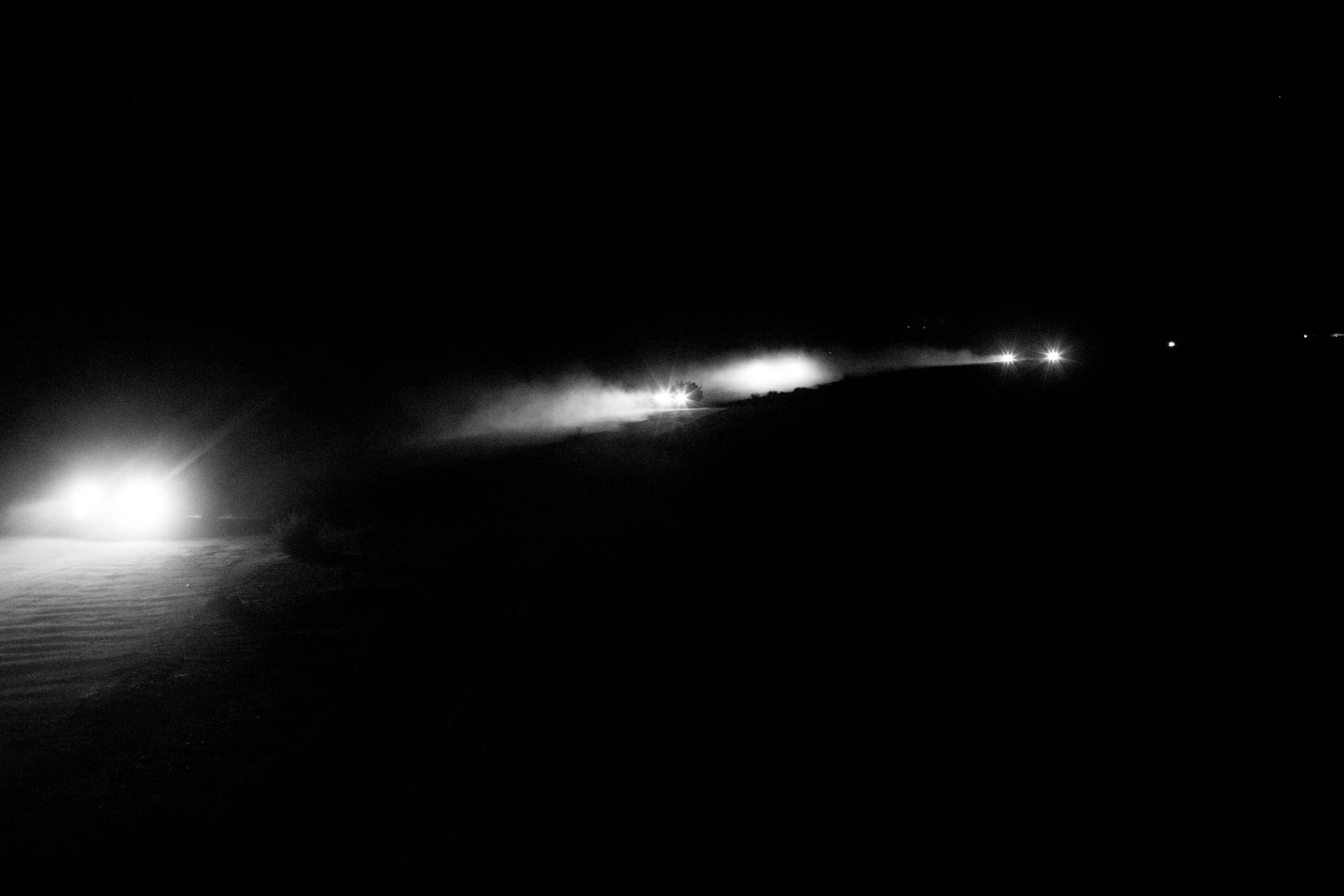 The lights of trucks carrying migrants to Libya dot the desert horizon in northern Niger. Over 100 trucks leave the town of Agadez every Monday evening, each pickup carrying 20-25 migrants all with hopes of reaching Europe.