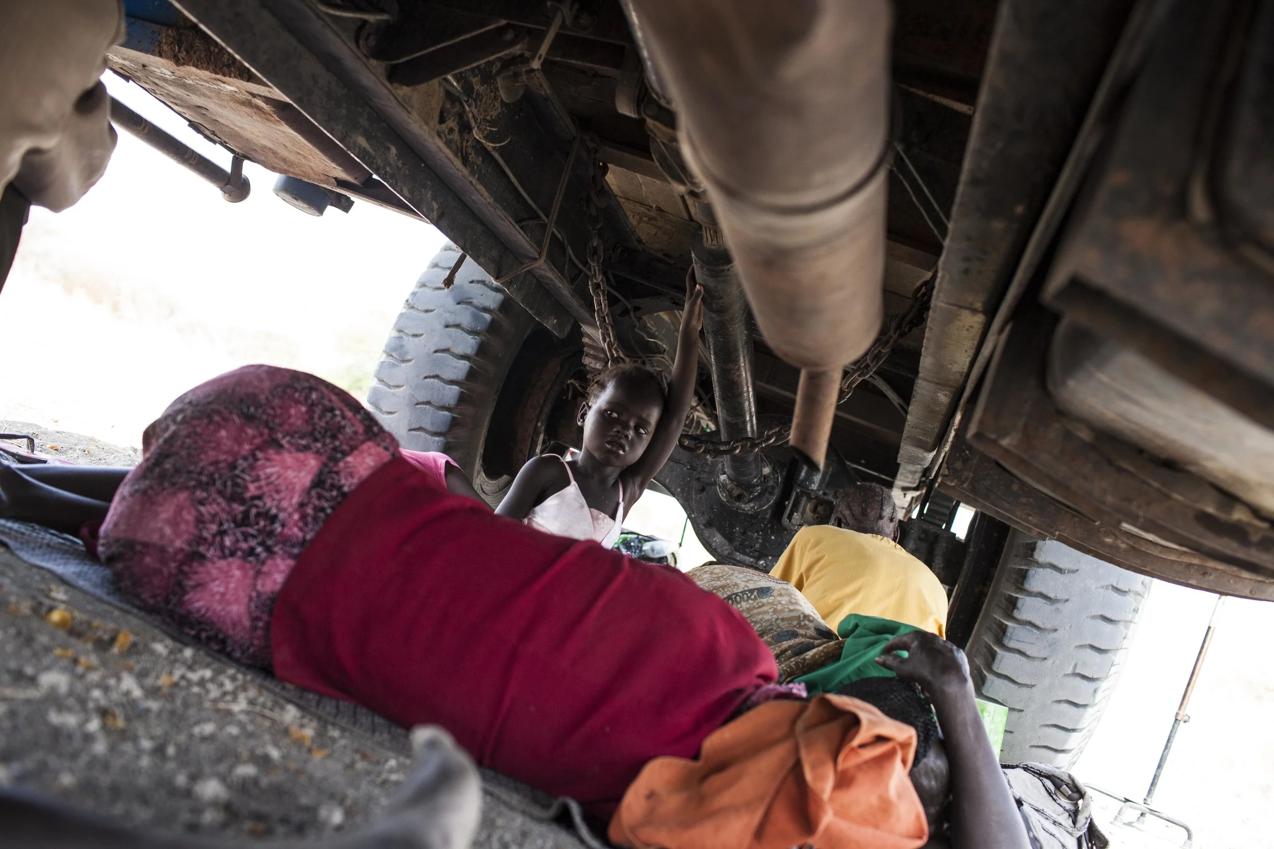 Adut holds onto the bus chassis, too thirsty and hungry to sleep.