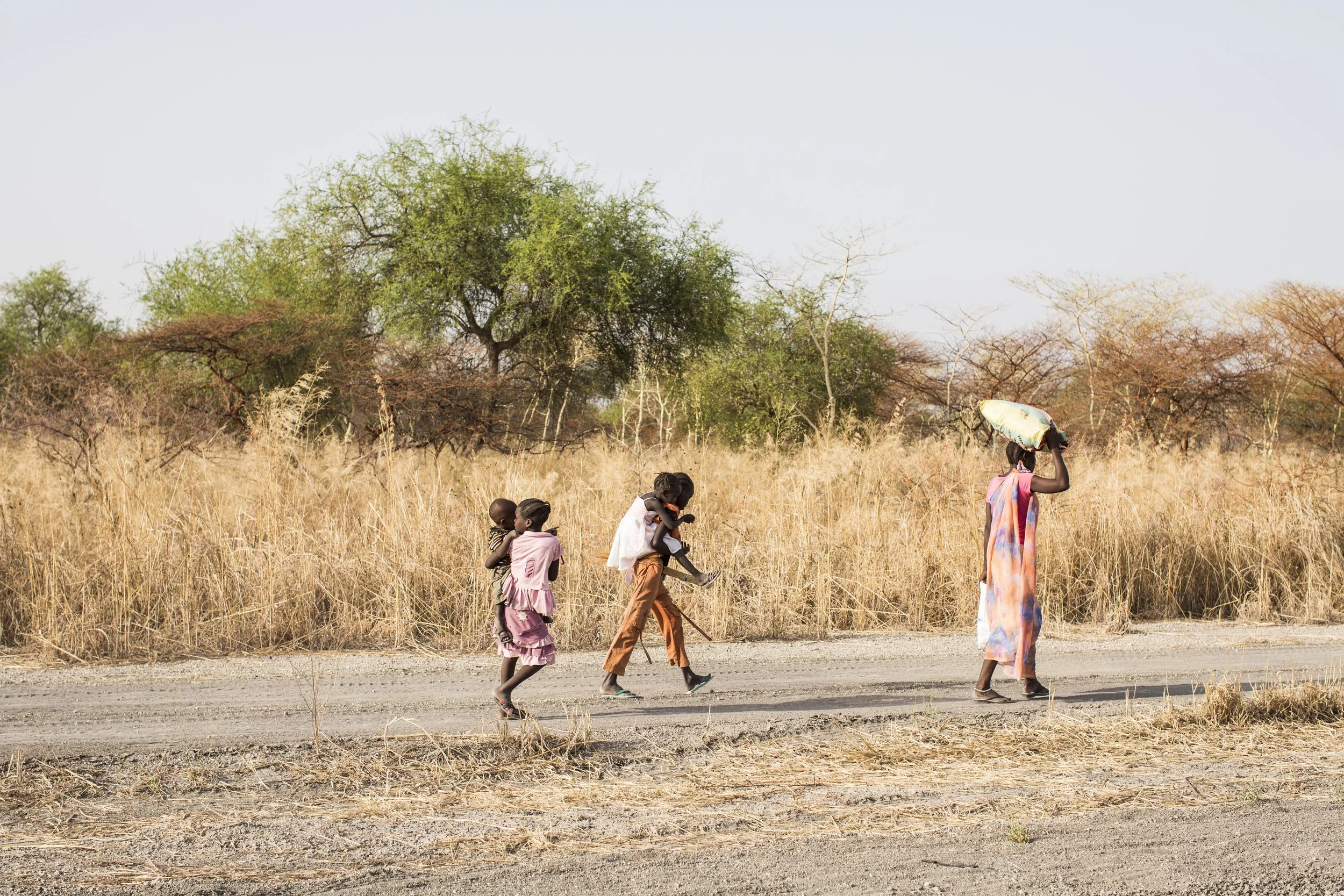 Regina leads the way to Akoka as Bor carries Adut and Akon carries Anuen. Kuany delays his departure in order to organize a small amount of water for those too sick to make the journey.