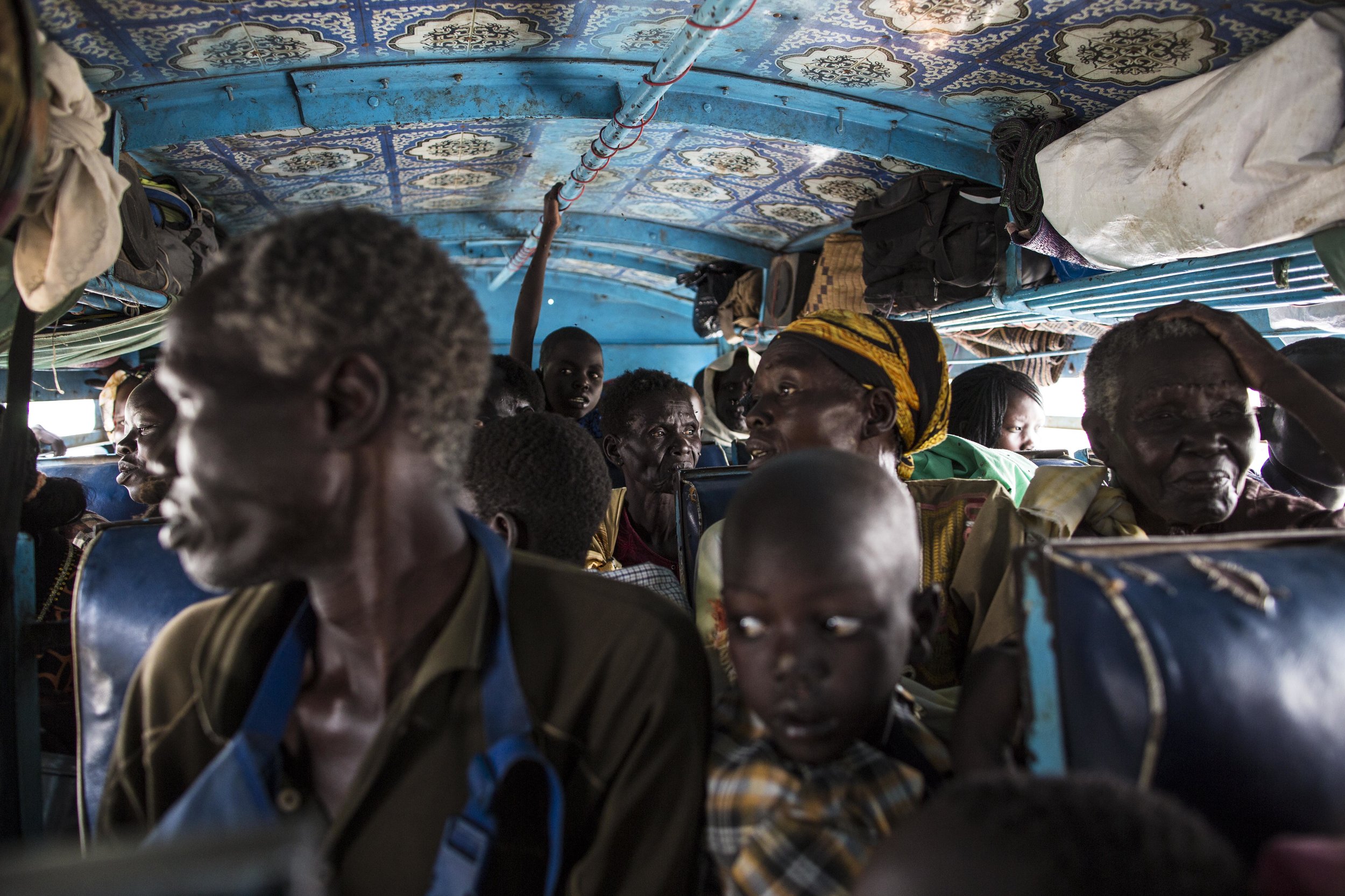 Passengers look out the windows as the bus departs Malakal.