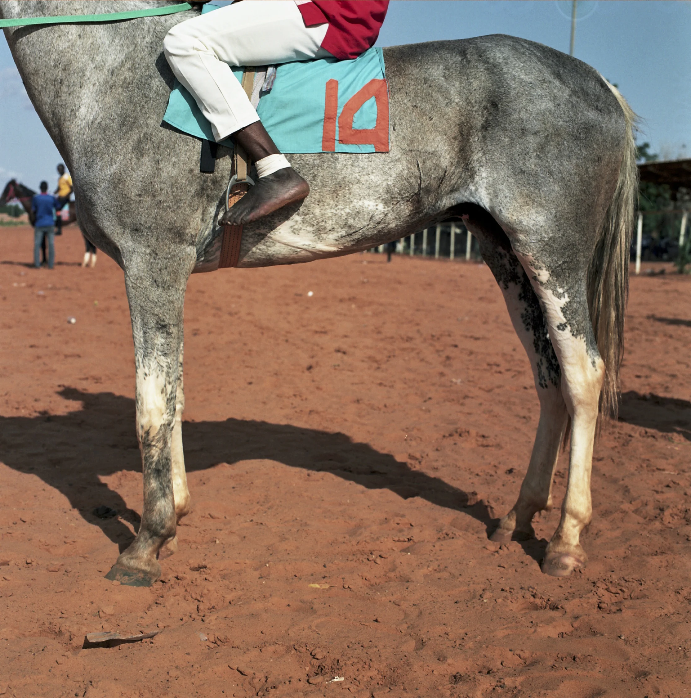 A jockey races in barefeet to save weight.