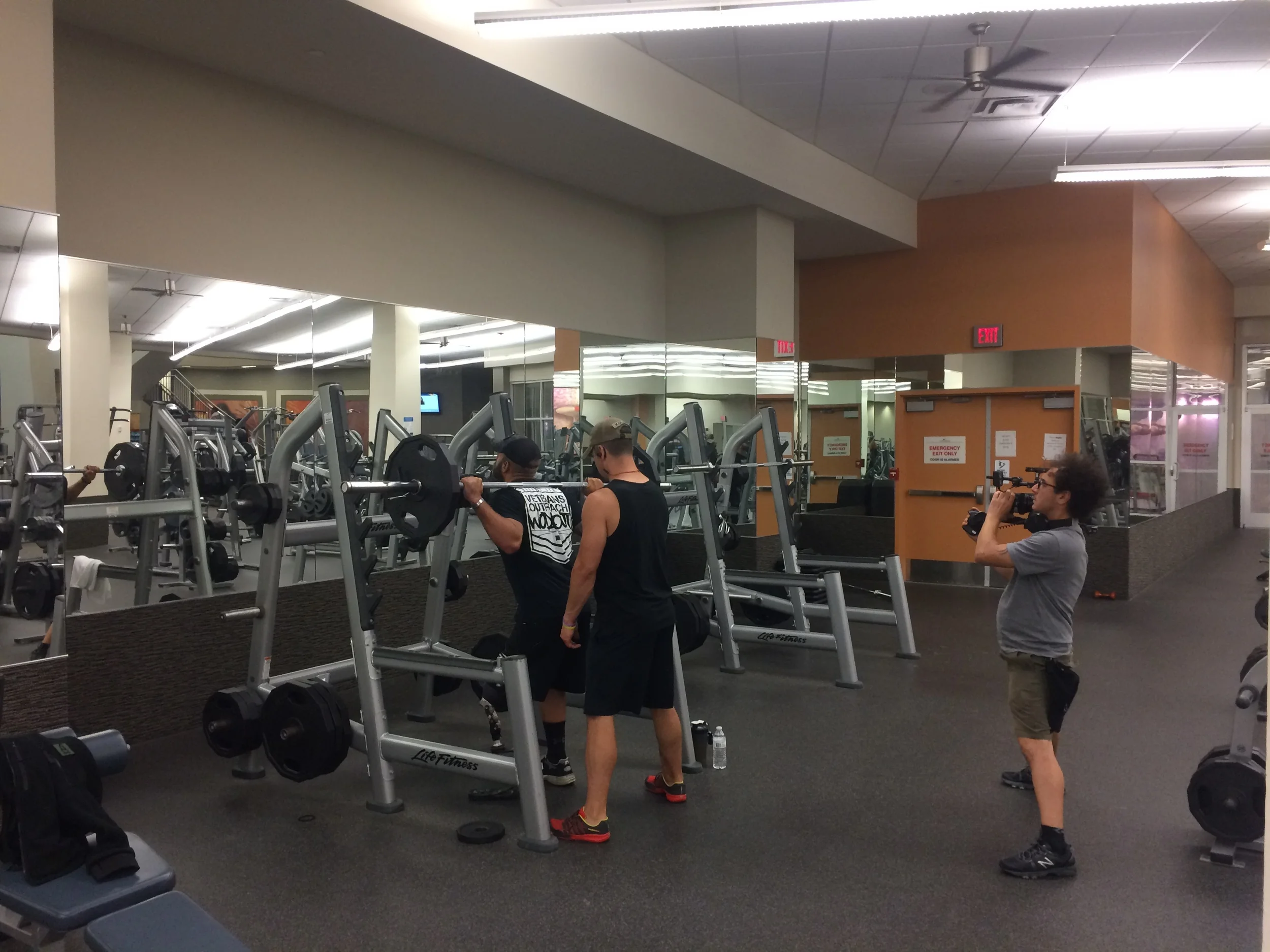 Nico filming Earl and Rick talking bro science in deep squat
